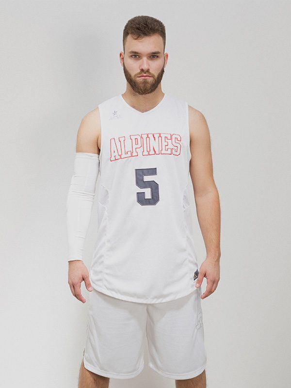 Male model wearing a white sleeveless basketball jersey, white shorts, and a white arm warmer on his right arm.