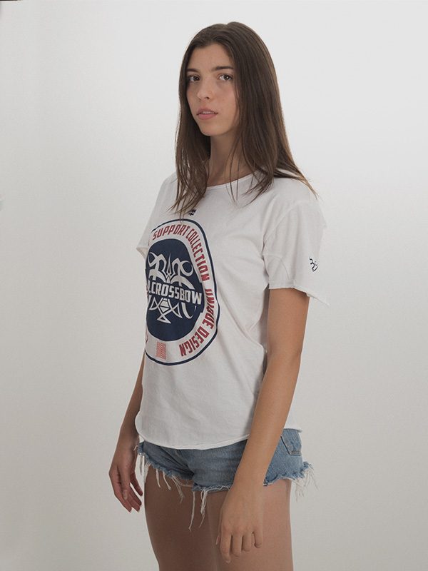 A female model wearing a white t-shirt with a big circular logo printed on the chest and stomach area.