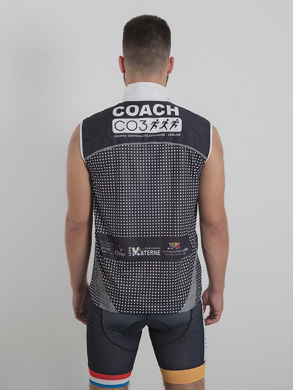 A made model wearing a grey and black custom-made running west with the white logo printed on the back. Back side is shown.