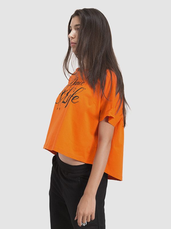 A female model wearing an orange zumba t-shirt. Left side is shown.